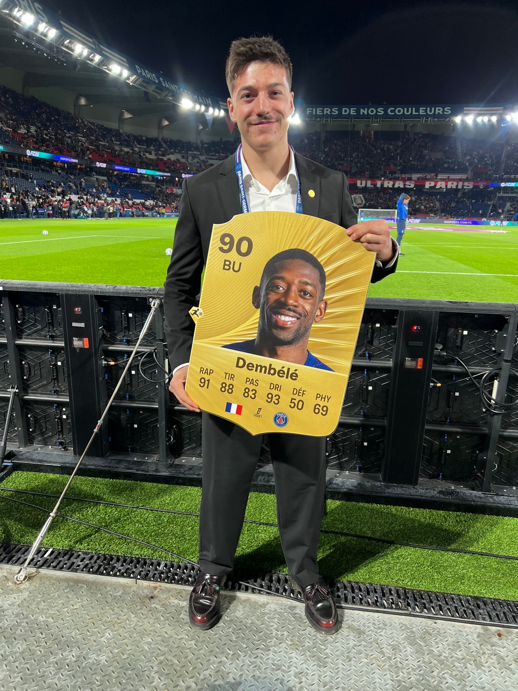 Holding an oversized player card on the pitchside LED boards at the Parc des Princes during a matchday activation.